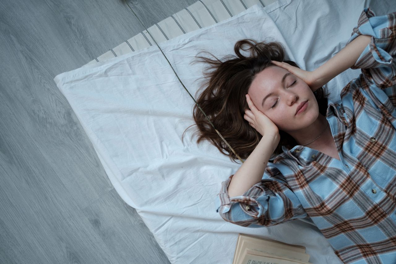 Services Young woman relaxing indoors on a bed, embracing tranquility and calmness.